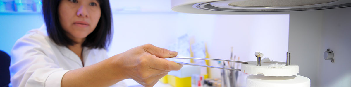 Dental technican firing a restoration in a furnace